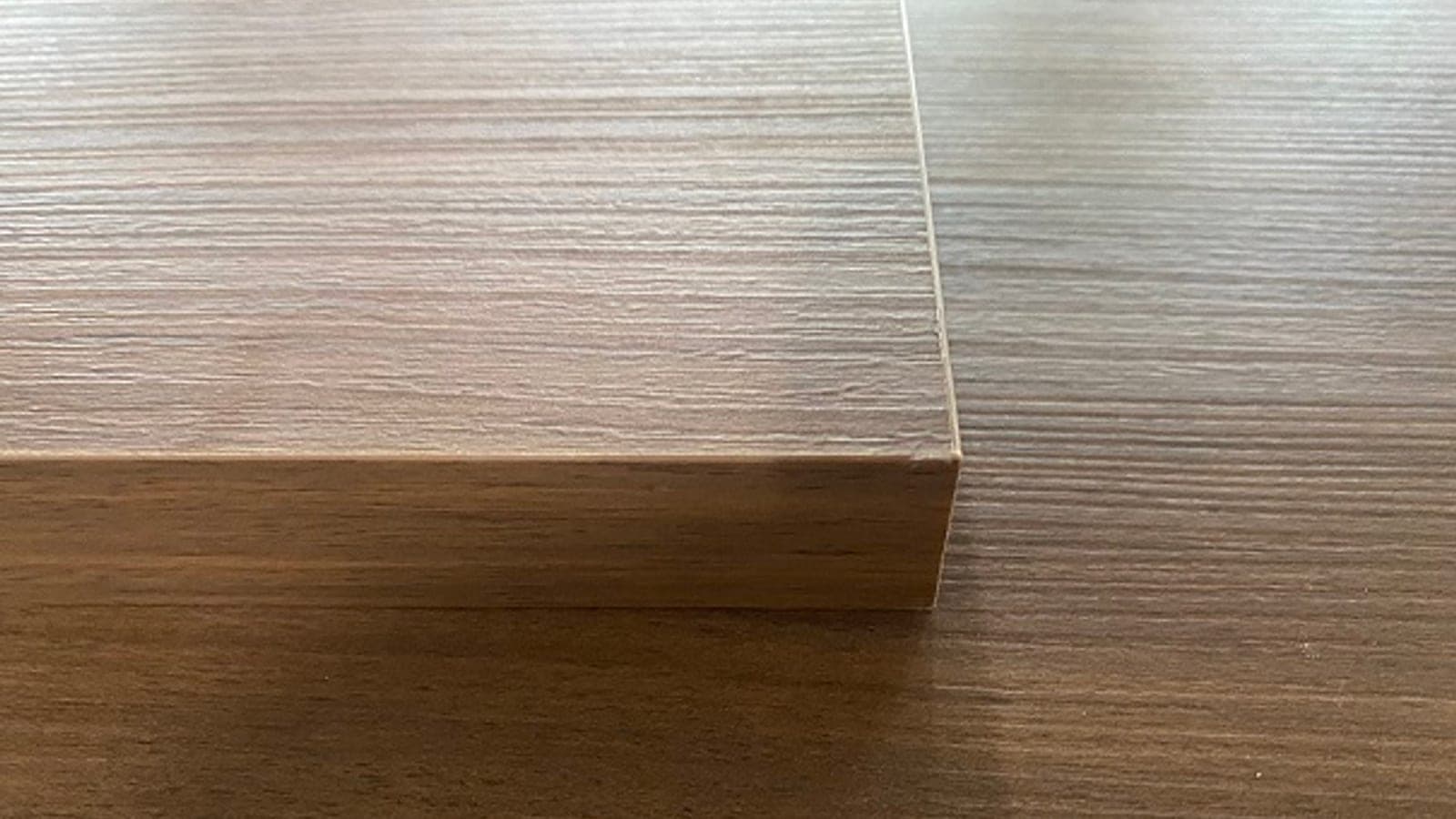 Cận cảnh mép ván ép công nghiệp với vân gỗ và lớp phủ bề mặt